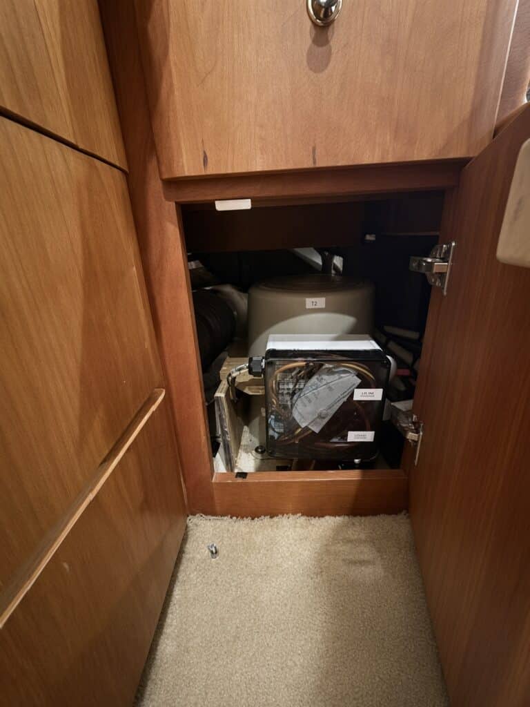 Marine-Puck isolation transformer and shore-power junction box installed inside a yacht cabinet, with the T2 unit behind the dockside and boat-side wiring enclosure.