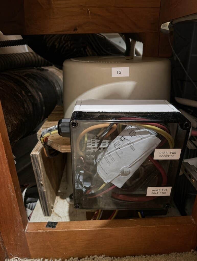 Shore-power junction box labeled dockside and boat side, wired in front of a Marine-Puck isolation transformer marked T2 during a dual-configuration install.